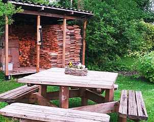 Houten picknickbank met houtopslag bij Vakantiehuis in Vriescheloo, ideaal voor buitenmaaltijden in Groningen.