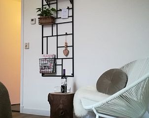 Comfortabele leeshoek in Vakantiehuis in Vriescheloo met wijn en tijdschriften in Groningen.