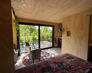 Slaapkamer met terras en uitzicht op de natuur bij Vakantiehuis in Bellingwolde, Zuidoost Groningen.