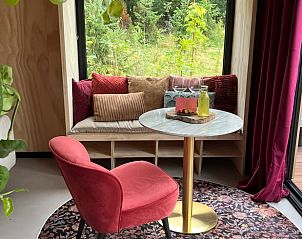 Stijlvolle zithoek met uitzicht op de tuin bij Vakantiehuis in Bellingwolde, Zuidoost Groningen.