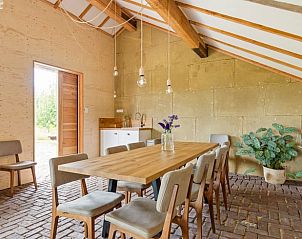 Stijlvolle eetkamer in Vakantiehuis in Bellingwolde met houten tafel en stoelen.