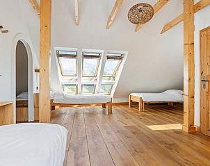 Lichte slaapkamer met houten details in Vakantiehuis in Bellingwolde.