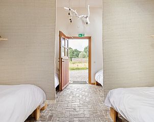 Slaapruimte met open deur naar buiten in Vakantiehuis in Bellingwolde.