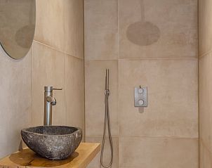 Stijlvolle douche met natuurstenen wastafel in Vakantiehuis in Bellingwolde.