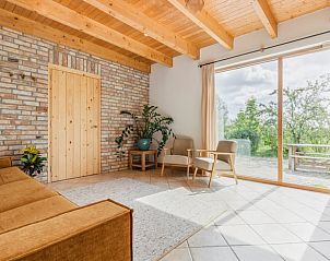 Gezellige woonkamer met uitzicht op de tuin in Vakantiehuis in Bellingwolde.