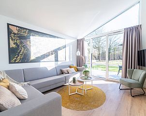 Lichte woonkamer van de vrijstaande woning in Sellingen met uitzicht op tuin in Zuidoost Groningen, Groningen.