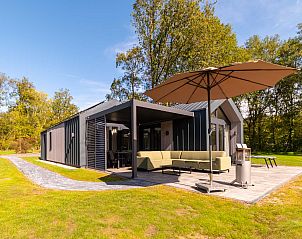 Zonnige veranda van Vrijstaande woning in Sellingen, vakantiehuis in Zuidoost Groningen, omgeven door groen.