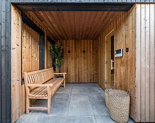 Sauna bij Vrijstaande woning in Sellingen met houten bank en planten in Groningen.