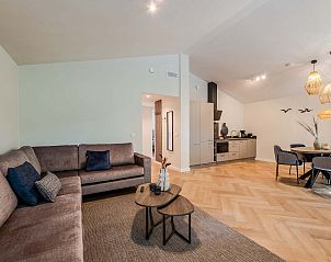 Ruime woonkamer met eetgedeelte in vakantiehuis Sellingen, Groningen.