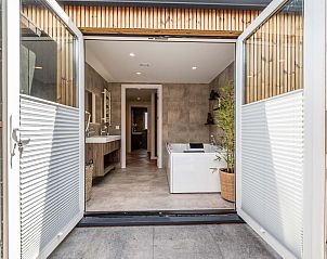 Buitenzijde van badkamer in vakantiehuis Sellingen, Groningen met toegang tot terras.