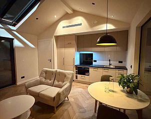 Sfeervolle woonkamer met open haard in vakantiehuis in Sellingen, Zuidoost Groningen, Groningen.