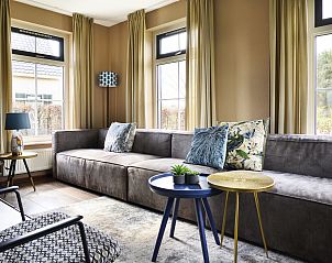 Stijlvolle woonkamer in Vakantiehuis Lieskehuis Wellness de Luxe 10+2, Vlagtwedde, met comfortabele zitplaatsen en moderne inrichting.