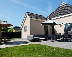 Zonnig terras met zitgelegenheid bij Vakantiehuis Lieskehuis Wellness de Luxe 10+2, Vlagtwedde, ideaal voor buiten dineren.