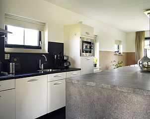 Strakke keuken met kookeiland in Vakantiehuis Lieskehuis Wellness de Luxe 10+2, Vlagtwedde, ideaal voor kookliefhebbers.