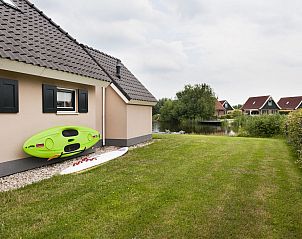 Ruime tuin met waterzicht bij Vakantiehuis Lieskehuis Wellness de Luxe 10+2, Vlagtwedde, ideaal voor buitenactiviteiten.