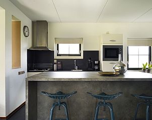 Moderne keuken met barstoelen in Vakantiehuis Lieskehuis Wellness de Luxe 10+2, Vlagtwedde, ideaal voor gezellige maaltijden.