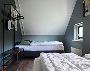 Slaapkamer met twee bedden in Vakantiehuis Lieskehuis Wellness de Luxe 10+2, Vlagtwedde, ideaal voor gezinnen in Groningen.