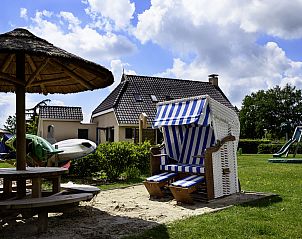 Rustieke strandstoel in de tuin van Vakantiehuis Lieskehuis Wellness de Luxe 10+2, Vlagtwedde, voor ontspannen momenten.