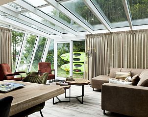Lichte woonkamer in Vakantiehuis Metbroekhuis Wellness de Luxe, Vlagtwedde, met glazen dak en uitzicht op de natuur.