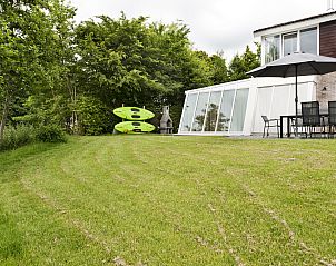 Ruime tuin van Vakantiehuis Metbroekhuis Wellness de Luxe, Vlagtwedde, met serre en kajaks.