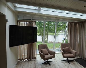 Luxe zithoek met groot raam in Vakantiehuis Metbroekhuis Wellness de Luxe, Vlagtwedde, met uitzicht op het meer.
