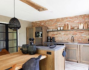 Stijlvolle keuken met bakstenen muur in Vakantiehuis Metbroekhuis Wellness de Luxe, Vlagtwedde, Groningen.