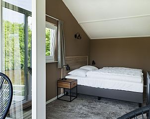 Comfortabele slaapkamer in Vakantiehuis Metbroekhuis Wellness de Luxe, Vlagtwedde, met uitzicht op de tuin.