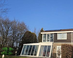 Exterieur van Vakantiehuis Metbroekhuis Wellness de Luxe, Vlagtwedde, met grote ramen en blauwe lucht.