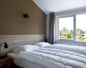 Gezellige slaapkamer met uitzicht op het meer in Vakantiehuis Metbroekhuis Wellness de Luxe, Vlagtwedde.