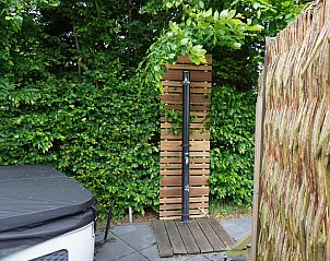 Buitendouche naast het bubbelbad bij Vakantiehuis Metbroekhuis Wellness de Luxe, Vlagtwedde, voor ultieme verfrissing.