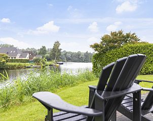 Adirondack stoelen met uitzicht op het water bij Vakantiehuis Heerd Wellness de Luxe, Vlagtwedde, Groningen.