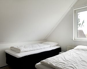 Slaapkamer met enkel bed in Vakantiehuis Vrieschehuis Comfort Royaal, Vlagtwedde, ideaal voor een ontspannen verblijf in Groningen.