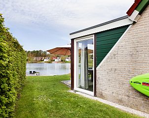 Buitenzijde van Vakantiehuis Vrieschehuis Comfort Royaal in Vlagtwedde, met directe toegang tot de tuin en uitzicht op het water.