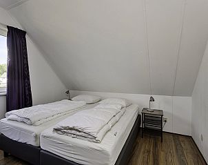 Slaapkamer met tweepersoonsbed in Vakantiehuis Bellingwolde Comfort, Groningen.
