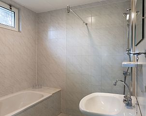 Badkamer met bad en douche in Vakantiehuis Bellingwolde Comfort, Groningen.