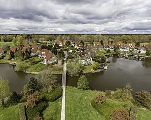 Luchtfoto van Vakantiehuis Ruiten AA comfort in Vlagtwedde, Groningen, met uitzicht op het meer en groene omgeving.