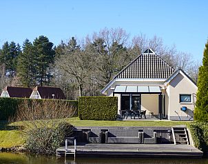 Vakantiehuis Vosseberghuis Prestige & Outdoor Spa in Vlagtwedde met terras aan het water, omgeven door natuur.