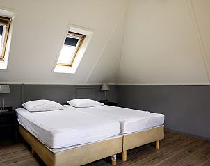 Lichte slaapkamer met twee bedden in Vakantiehuis Vosseberghuis Prestige & Outdoor Spa, Vlagtwedde, Groningen.