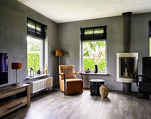 Moderne woonkamer in Vakantiehuis Vosseberghuis Prestige & Outdoor Spa, Vlagtwedde, met veel lichtinval.