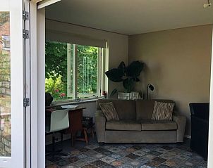 Gemoedelijke woonkamer van Huisje in Slochteren, vakantiehuis in Groningen met grote ramen en tuinzicht.