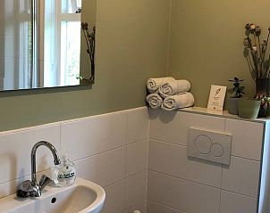 Stijlvolle badkamer in Huisje in Slochteren, vakantiehuis in Groningen met moderne wastafel en handdoeken.