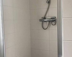 Moderne douche in Huisje in Slochteren, vakantiehuis in Groningen met strakke witte tegels.