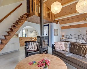 Gezellige woonkamer met open haard in Vakantiehuis Westerwolde, Onstwedde, perfect voor een knusse vakantie in Groningen.