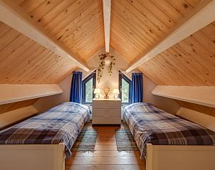 Knusse zolderkamer met twee bedden in Vakantiehuis Westerwolde, Onstwedde, ideaal voor een familievakantie in Groningen.