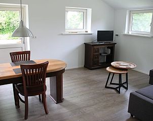 Eetkamer en zithoek in Huisje in Mussel, vakantiehuis in Zuidoost Groningen, met houten meubels.