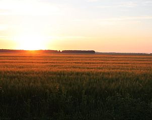 Adembenemende zonsondergang over de velden bij Huisje in Mussel, vakantiehuis in Zuidoost Groningen.