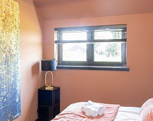 Gezellige slaapkamer in Vakantiehuisje in Kiel-Windeweer, Zuidoost Groningen, met warme kleuren en een comfortabel bed.