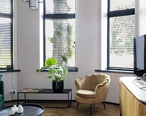 Moderne woonkamer in Vakantiehuisje in Kiel-Windeweer, Zuidoost Groningen, met grote ramen en een stijlvolle inrichting.