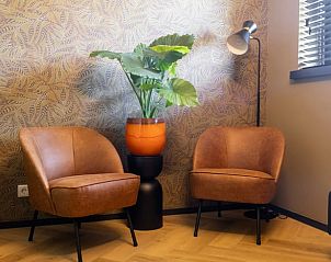 Gezellige zithoek in Vakantiehuisje in Kiel-Windeweer, Zuidoost Groningen, met comfortabele stoelen en een groene plant.