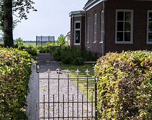 Toegangspoort tot Vakantiehuisje in Kiel-Windeweer, Zuidoost Groningen, omgeven door groene heggen en een rustige omgeving.